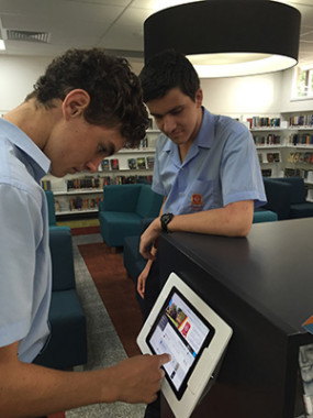 School students on tablet in library